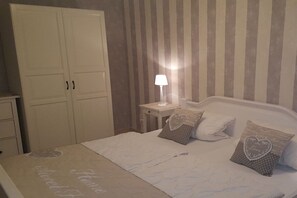 A bedroom with a bed, pillows, a nightstand, a lamp, and a wardrobe. - Holiday home with 1 bedroom (Ostseebad Rerik)