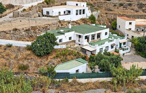 Zona residencial con casas blancas, tejados verdes y un paisaje montañoso.
