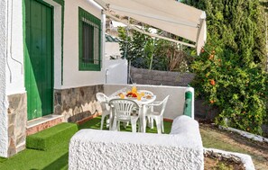 A patio with a table set for breakfast, outdoor seating, and a green door. - Amazing home in Adra with WiFi (Adra)