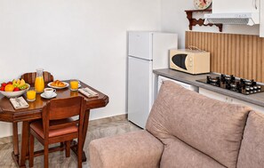 A compact kitchenette with a microwave, a refrigerator, and a gas stove. - Amazing home in Adra with WiFi (Adra)