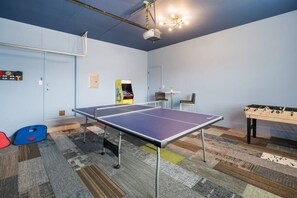 A room with a ping pong table, a foosball table, and a small arcade machine. - Heated Pool & Outdoor Theater, Close to DT, UT (Austin)