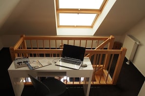 A room with a skylight, a laptop on a desk, and a chair. - Holiday apartment with 1 bedroom (Großenbrode)