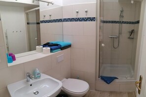 Kylpyhuone, jossa on pesuallas, wc ja suihkutila.