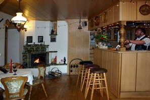 A restaurant interior with wooden furniture, a bar area, and a fireplace. - and holiday apartments "Zaukeneck" (Bad Schandau\/Rathmannsdorf)