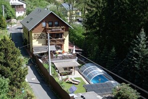 Ein zweistöckiges Gebäude mit Balkon, Schwimmbad und Wintergarten.