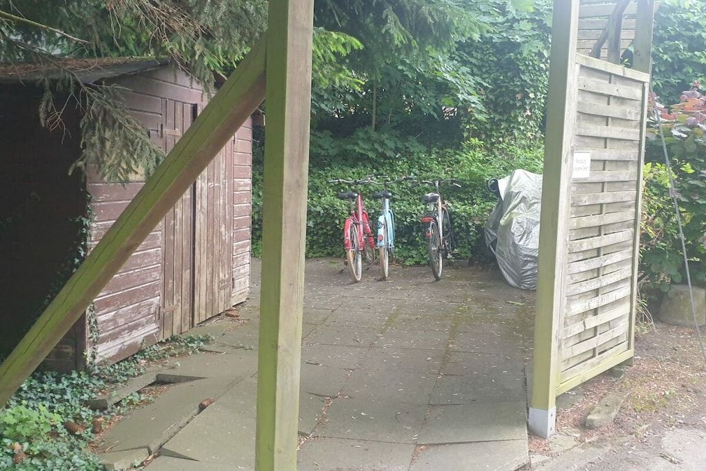Un chemin menant à une structure en bois, avec des vélos garés à proximité.