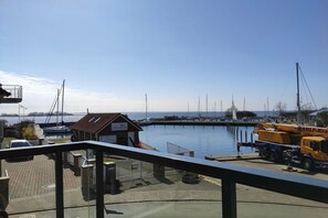 A marina with boats docked, a small building, and a crane on the right. - Holiday apartment with 2 bedrooms (Fehmarn OT Lemkenhafen)