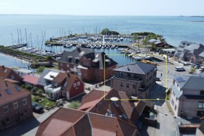 A marina with boats, a dock, and residential buildings with red roofs. - Holiday apartment with 2 bedrooms (Fehmarn OT Lemkenhafen)
