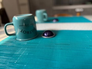 A close-up of a teal mug with text on it, placed on a textured surface.