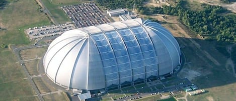 A large, dome-shaped building with a parking lot and a smaller adjacent structure.