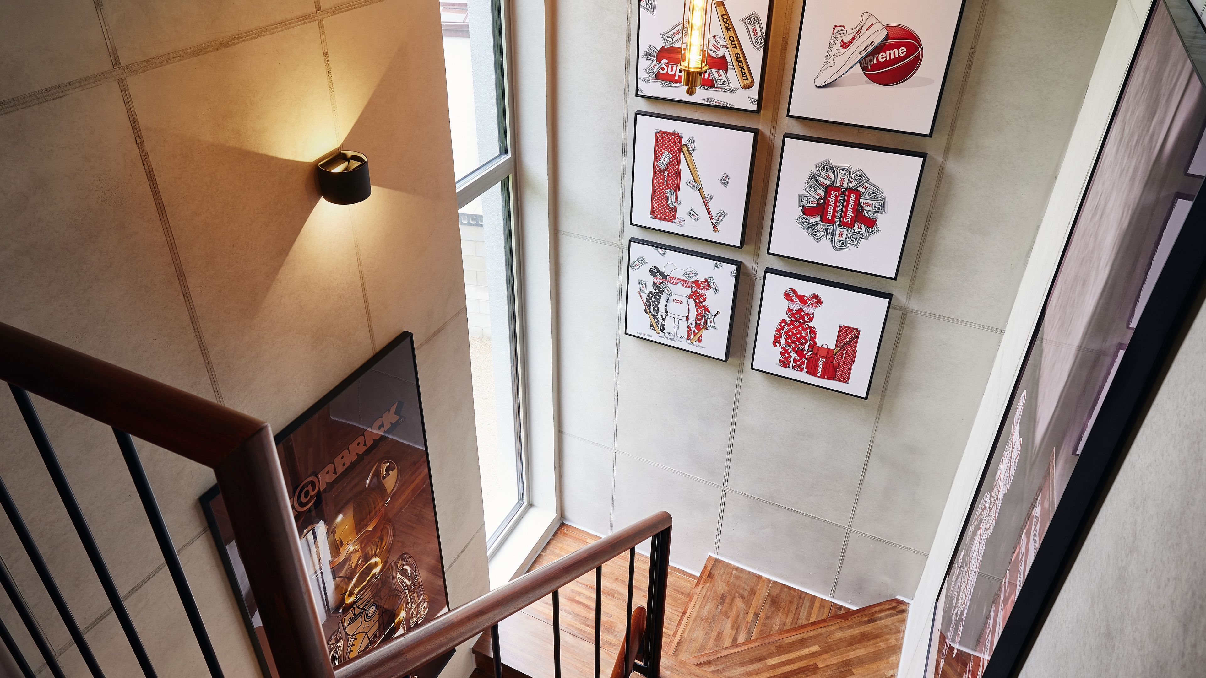 A staircase with a handrail and a wall with framed artwork.