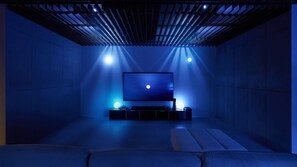 Une salle de cinéma moderne dotée d’un grand écran, de sièges confortables et d’un éclairage d’ambiance.
