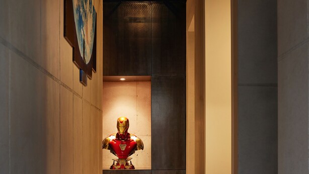 A corridor with a statue of a character in a red and gold suit.
