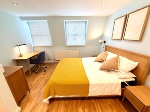 A bedroom with a bed, bedside tables, a desk, and a chair. - Flat 4 Beautiful Central London Apartment (London)