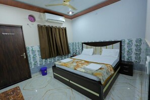Un dormitorio con cama, cortinas, aire acondicionado, ventilador de techo y pared con diseño.