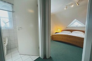 A bedroom with a bed, a window, and a skylight. - Holiday home with 1 bedroom (St. Peter - Ording)