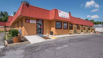 A standalone building with a red roof and a sign indicating a breakfast bar and to-go options.