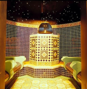 Un baño con techo estrellado, baldosas estampadas y dos lavamanos verdes.