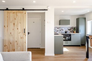 A modern kitchen with a central island, a sliding door, and a visible WC. - Apartment in Zandvoort with balcony and Wi-Fi (Zandvoort)