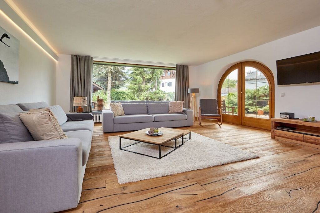 Een moderne woonkamer met een bank, een salontafel en een televisie.