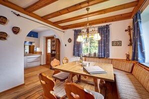 Ein Essbereich mit Holztisch und Stühlen, einer Bank und einer Pendelleuchte.
