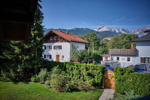 Ein Wohngebiet mit einem weißen Haus, einem Holzzaun und Blick auf die Berge.