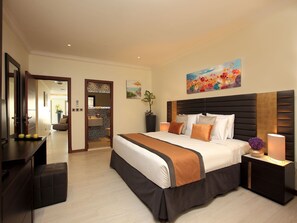 Quarto de hotel com cama grande, mesas de cabeceira, escrivaninha e espelho.