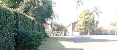 Un cartel señalizador en un área ajardinada, con una carretera al fondo.