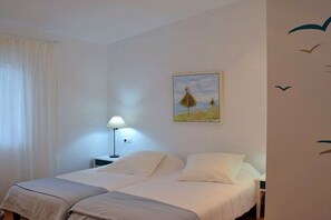 A double bed with white bedding, a bedside table with a lamp, and a painting on the wall. - Finca in Muro with swimming pool (Muro)