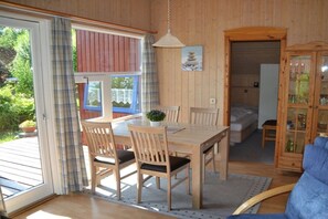 Ein Holzinterieur mit Esstisch und Stühlen, einem Bett und einem Schrank.