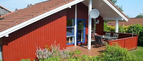 Ein rotes Gebäude mit einer weißen Veranda und einer Satellitenschüssel.