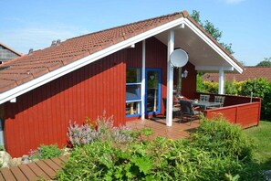 A red building with a white porch and a satellite dish. - Holiday home in Mönchneversdorf with Wi-Fi (Mönchneversdorf)