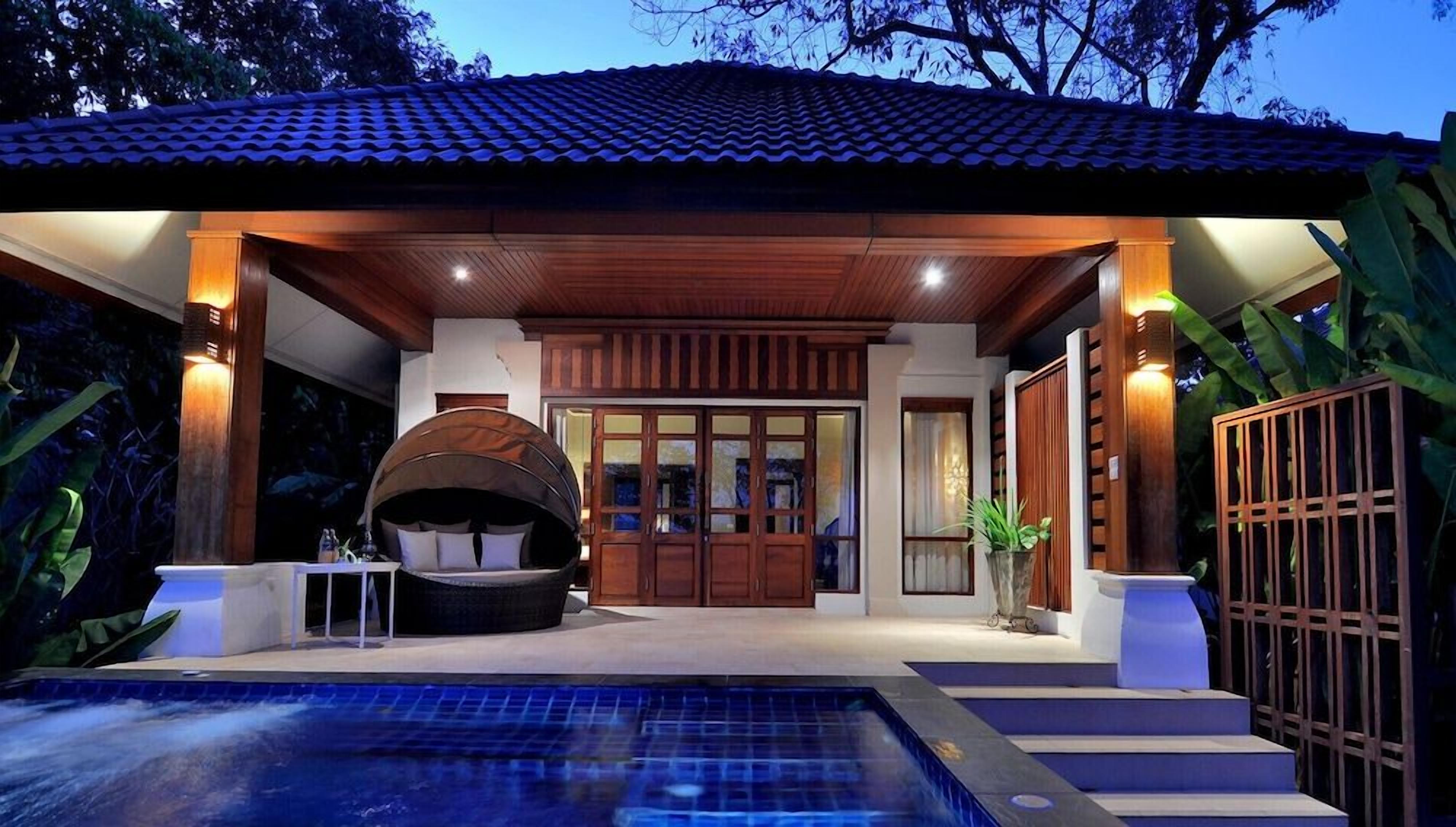 A modern outdoor pool area with a hot tub, wooden pergola, and a covered seating area.