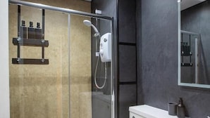 Un baño moderno con ducha envuelta en vidrio, inodoro y lavamanos.