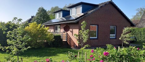 A two-story brick house with a sloped roof and a small front porch.