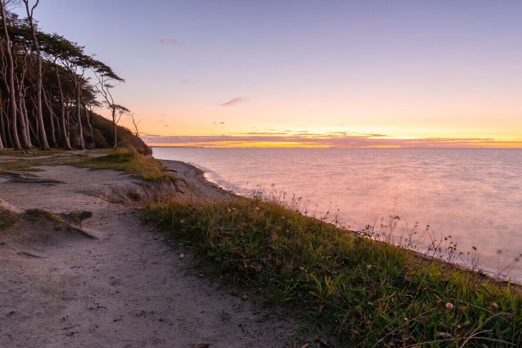 A coastal path with a view of the sea and trees.