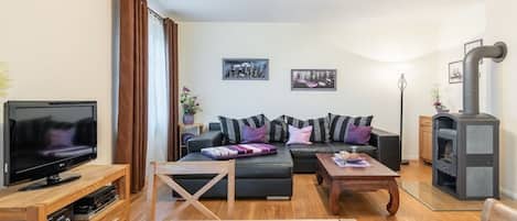 A modern living room with a sofa, a coffee table, a television, and a fireplace.
