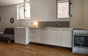 Eine kompakte Küche mit Backofen, Spüle und Herd.