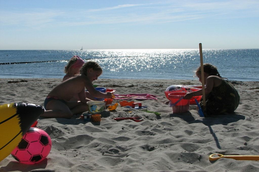 Een zandstrand met een voetbal en diverse strandspullen.