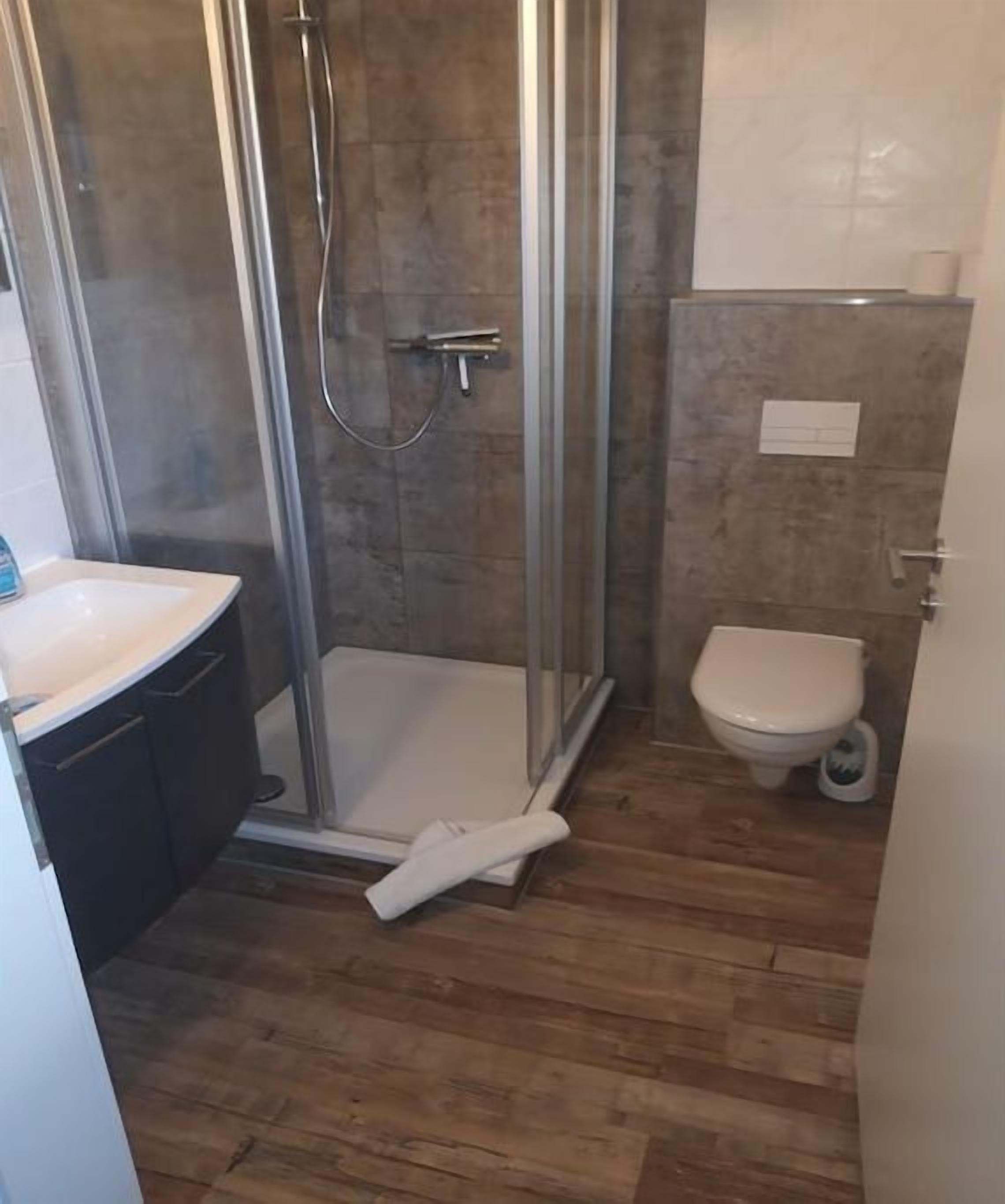 A bathroom with a shower, toilet, and sink.
