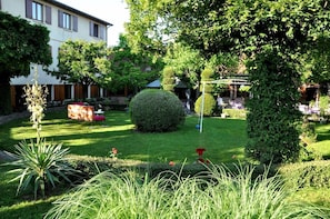 A well-maintained garden with a variety of plants and a neatly trimmed lawn. - Hotel Le Dahu (Parigny)