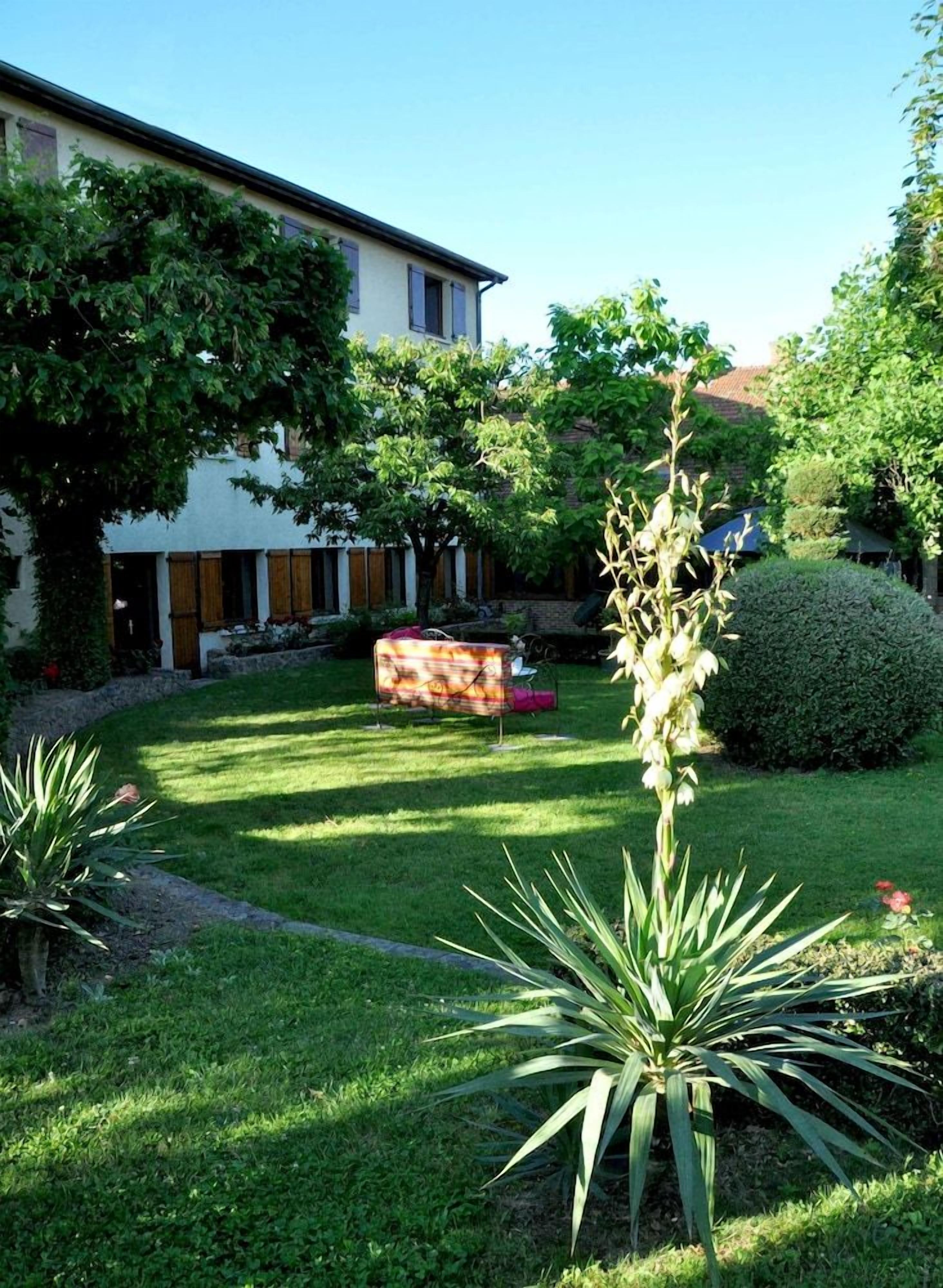 Un jardin bien entretenu, avec une grande variété de plantes, et un ciel dégagé.