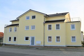 A two-story building with a flat roof and a balcony on the upper floor. - Holiday apartment with 2 bedrooms (Börgerende)
