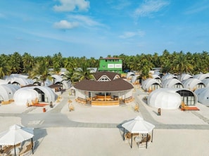 A resort with dome-shaped accommodations, a central building, and a palm tree-lined background. - Bangaram Island - Ihcl Seleqtions (Bangaram Island)