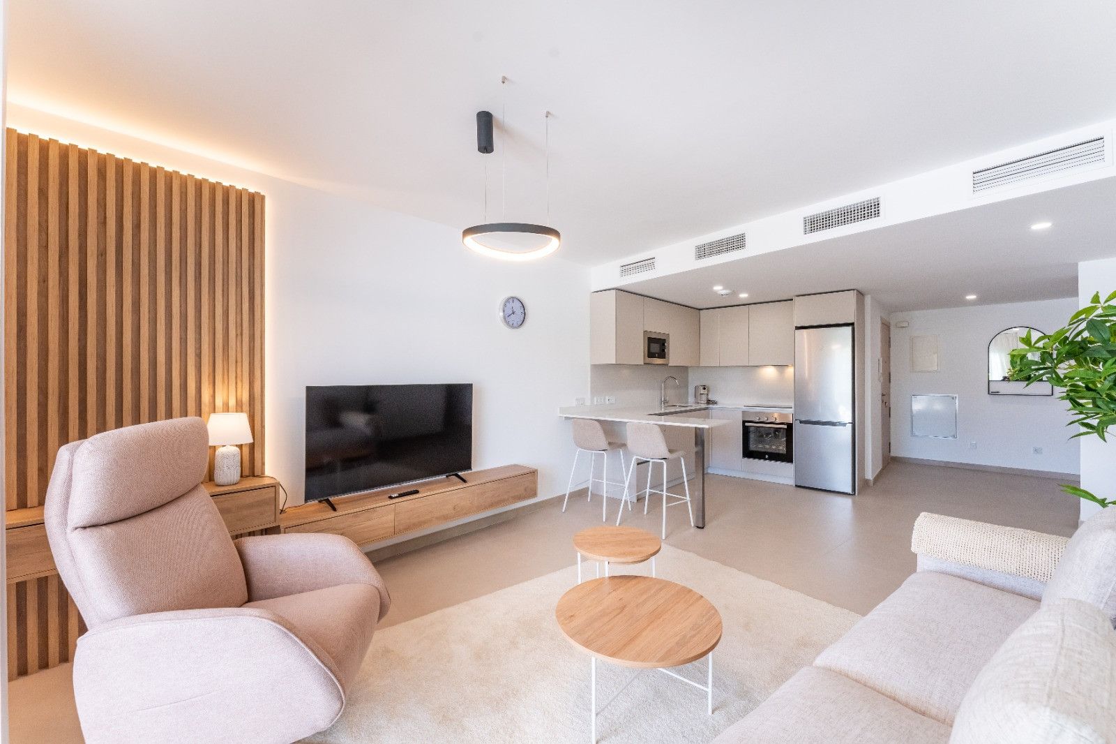 Un salon moderne avec un téléviseur à écran plat, un canapé et une table basse.