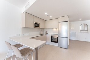 A modern kitchen with a central island, a built-in oven, and a refrigerator. - AMPHORA BEACH RESIDENCE 2476 MANILVA (Manilva)