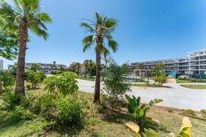 A hotel courtyard with palm trees, a swimming pool, and a building under construction. - AMPHORA BEACH RESIDENCE 2476 MANILVA (Manilva)