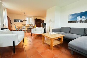 Ein Wohnzimmer mit einer Couch, einem Couchtisch und einem Essbereich mit Tisch und Stühlen.