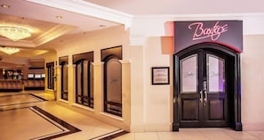 Eine Hotelhalle mit einer Rezeption, einem Schild mit der Aufschrift 'Boxers' und einem Hinweiszeichen an der Wand.
