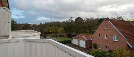 A residential area with a red brick house, a white garage, and a green lawn.